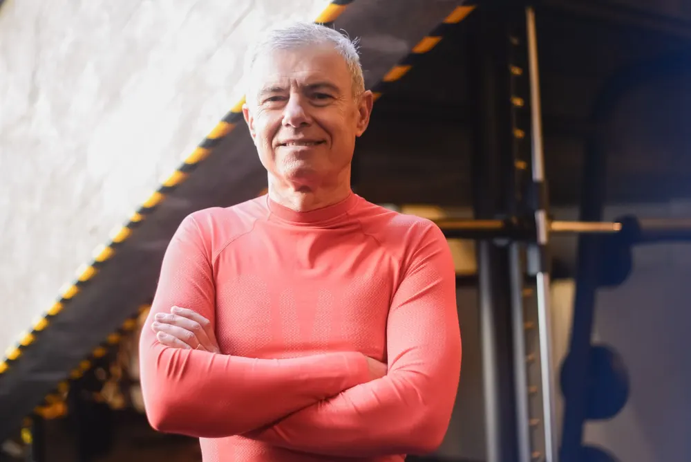 A confident silver-haired man in a gym